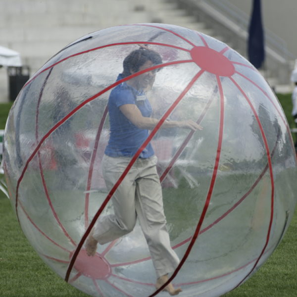 A woman having fun in a large plastic ball outside
