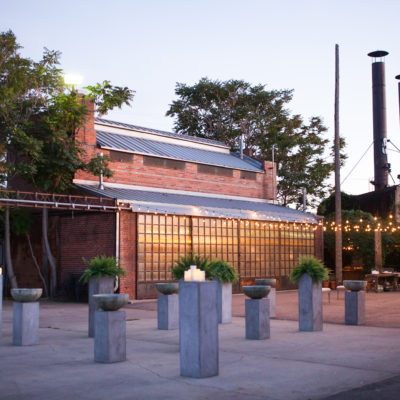 A red brick venue outside with a concrete patio with twinkle lights hanging above