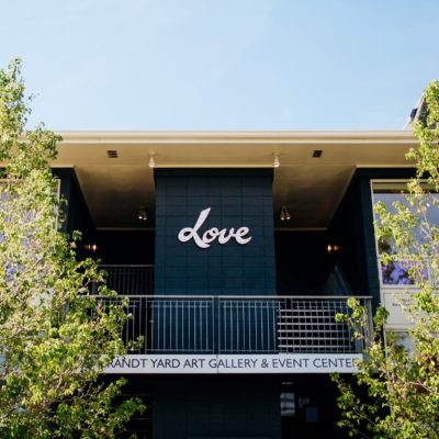A view of looking up at the Rembrandt Yard venue building. A sign saying 'Love' is in the center of the building