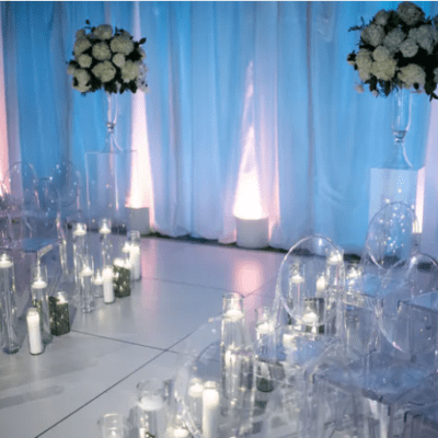 Wedding ceremony with clear chairs and tall candles