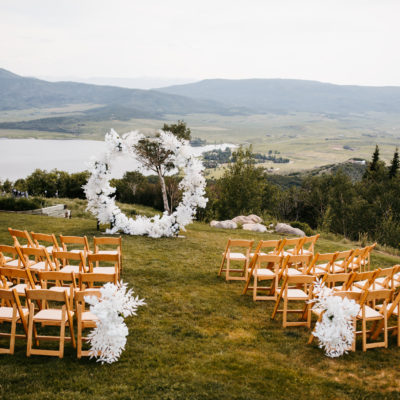 Outdoor wedding ceremony at Belle Vista Estate with wooden chairs and white details overlooking the mountains