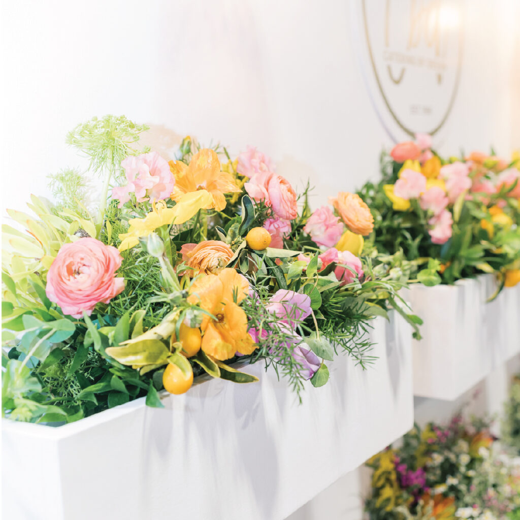 Pastel florals arranged in a rectangle container connected to a white wall.