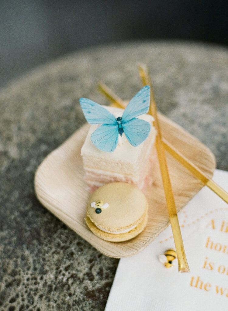 Ombre cake bite with a blue butterfly and yellow macaron cookie with a small bee decoration
