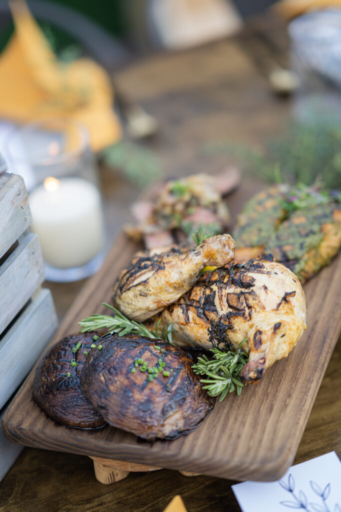 Grilled chicken breast and portobello mushrooms on a wood plank
