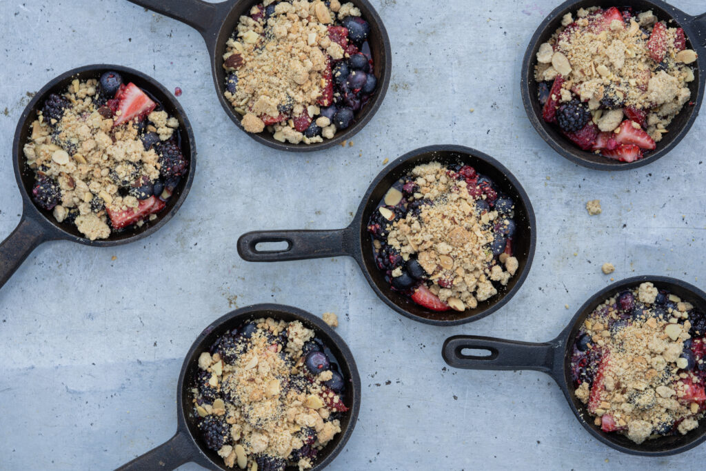 Mini skillets with fresh mixed berries and topped with a crumble